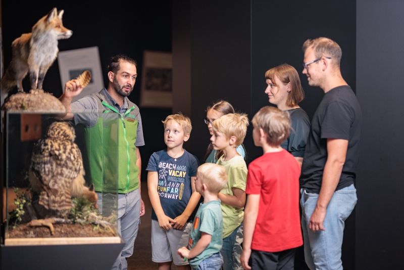 Ein Nationalparkmitarbeiter bei einer Erklärung für eine Familie 