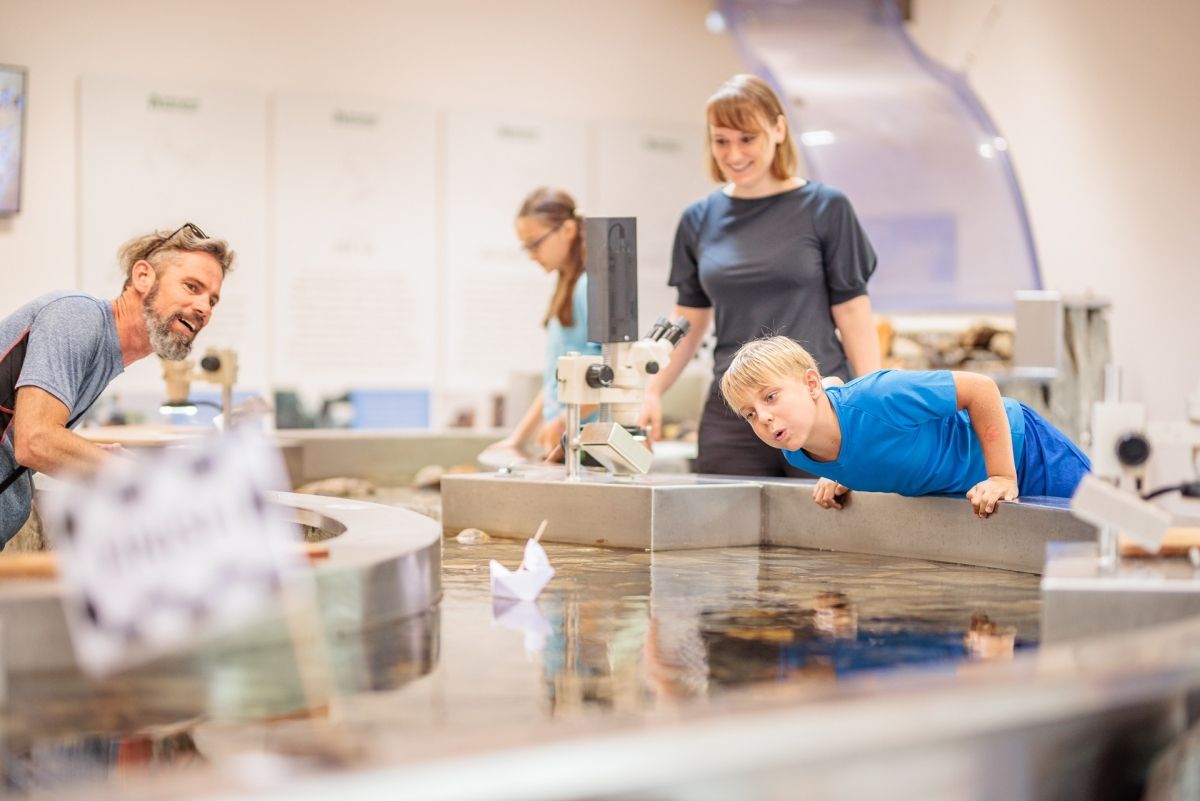 Eine Familie im Besucherzentrum Mallnitz bei einer Wasserstation